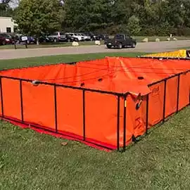 Folding frame tank with an orange liner and black frame, ideal for emergency water storage or fire-fighting support on grass fields.