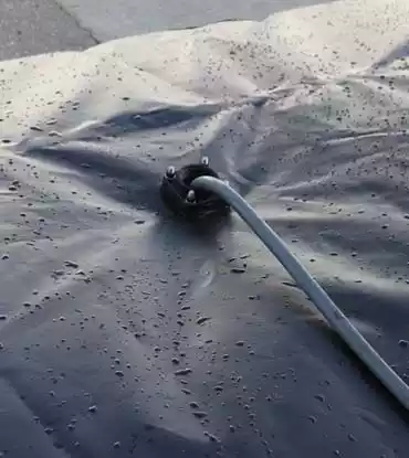 Close-up view of a collapsible water tank with a hose attached, showcasing the tank’s durability and adaptability for various uses.