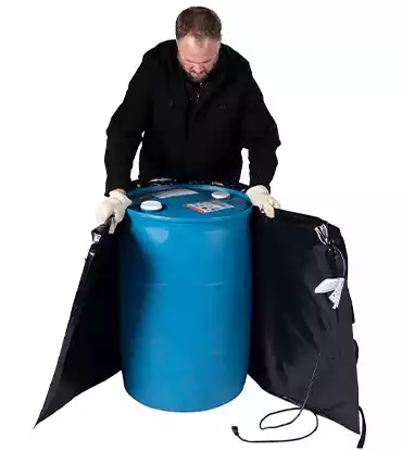 Man wrapping 55 gallon drum with a heater blanket