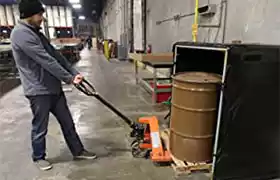 Man putting 55 gallon drum in a hot box